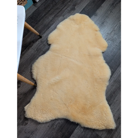 Cream-colored extra large angus oliver medical sheepskin rug with soft fluffy texture and natural irregular edges