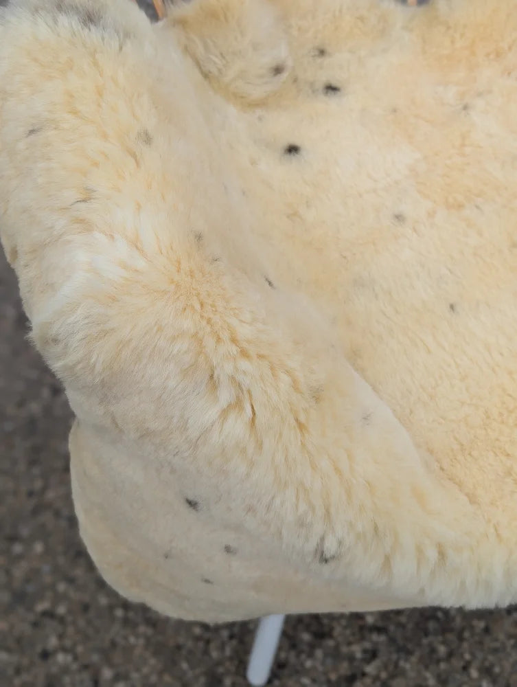 Cream-colored extra large washable medical sheepskin blanket with soft naturally spotted faux fur texture