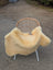 Cream-colored extra large washable medical sheepskin blanket in naturally spotted pattern draped over wicker chair