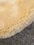 Cream-colored plush medical sheepskin car floor mat with soft fluffy texture naturally spotted and washable
