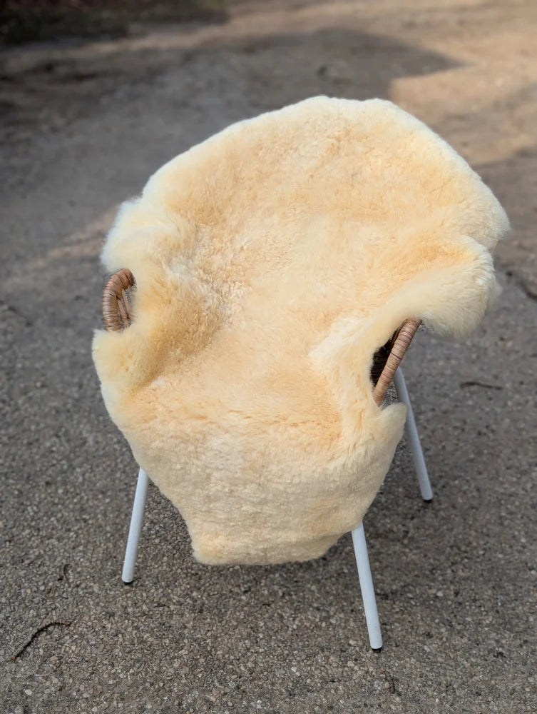 Cream-colored medical sheepskin chair cover with fluffy texture and woven handles extra large washable m-17