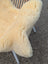 Cream-colored plush medical sheepskin chair cover with soft folds and naturally spotted texture for medical use
