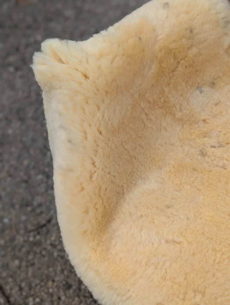 A soft creamy beige large washable medical sheepskin with a plush naturally spotted texture for comfort