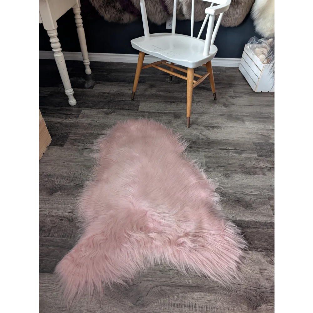 Soft pink Icelandic sheepskin rug with plush faux fur texture