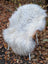 A plush fluffy natural grey icelandic sheepskin rug with long wool draped over a chair for cozy decor
