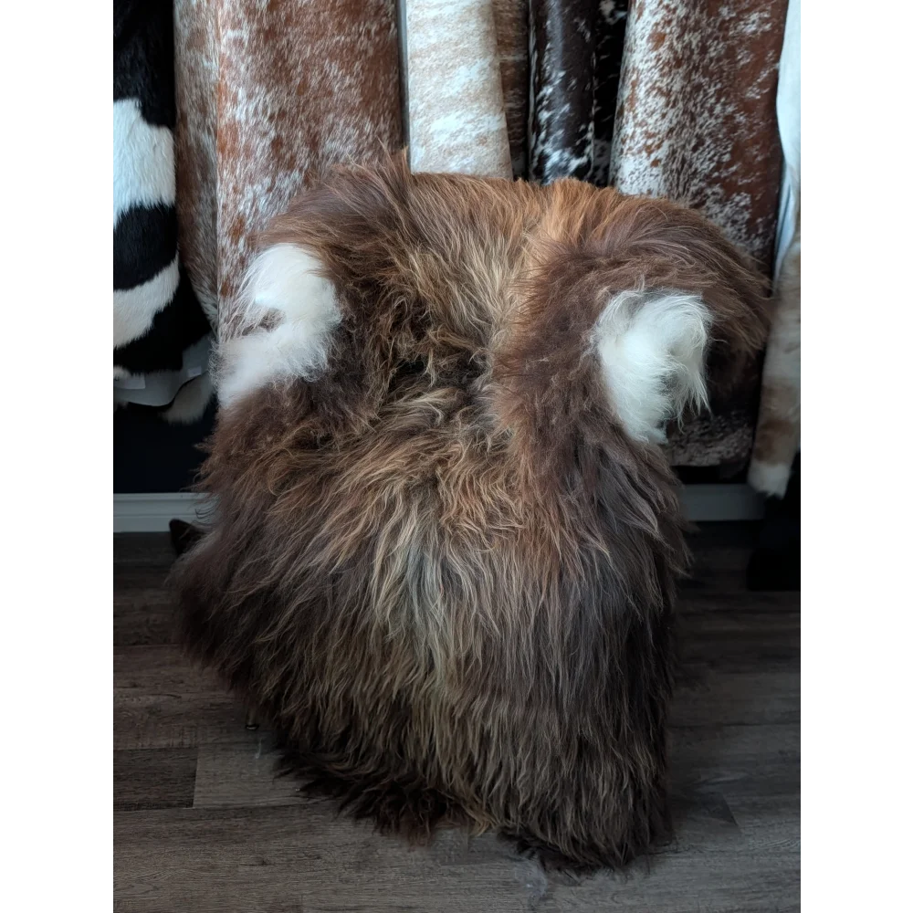 Massive icelandic sheepskin stool with long wool icelandic brown and white shaggy fur and soft textured surface