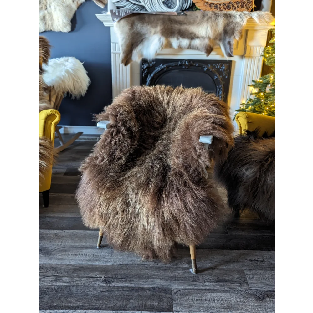 A plush brown massive icelandic sheepskin chair with long wool icelandic shaggy coat and slender wooden legs