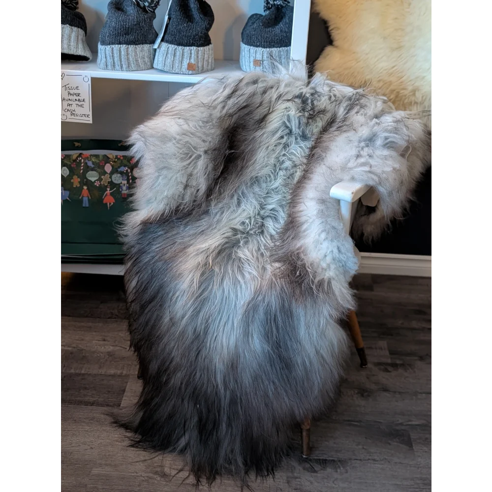 A plush icelandic sheepskin throw in natural grey draped over a chair with long soft wool icelandic fur