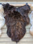 A thick shaggy dark rusty brown wool icelandic sheepskin rug with long fluffy fibers and natural color gradient