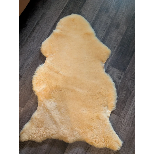 A soft pale yellow large sized medical sheepskin rug with fluffy texture and natural edges by angus oliver