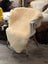 Cream-colored extra large med10 medical sheepskin throw draped over white wooden chair by angus oliver