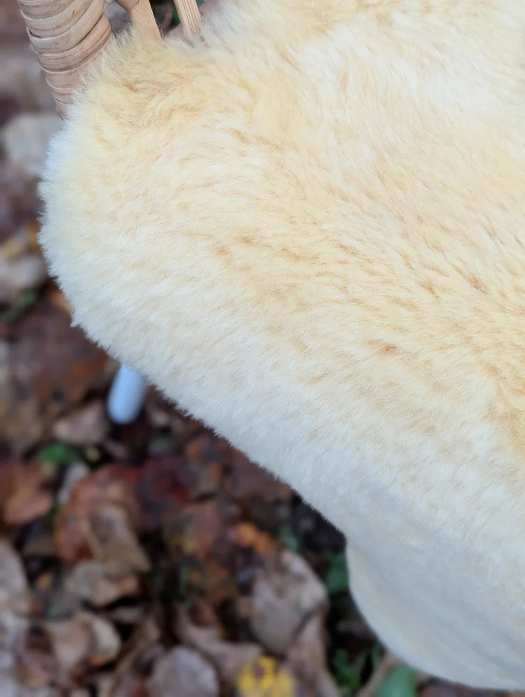 Cream-colored washable medical sheepskin chair cushion with soft fluffy texture and naturally spotted fibers