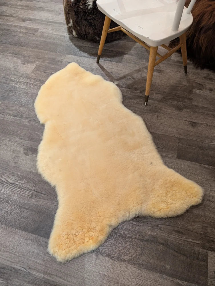 Cream-colored medical sheepskin rug with soft fluffy texture and natural edges by angus oliver extra large size