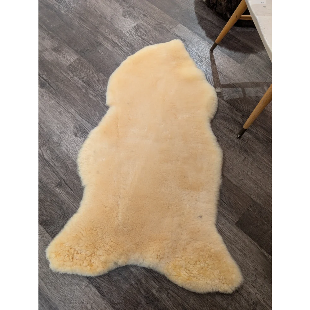 Cream-colored extra large medical sheepskin rug by angus oliver with soft fluffy texture and natural irregular edges