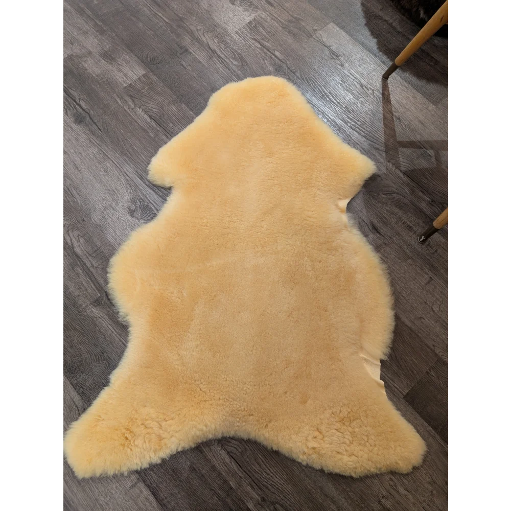 A soft pale yellow extra large medical sheepskin rug by angus oliver with natural fluffy texture and irregular edges