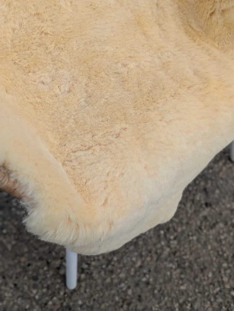 Cream-colored medical sheepskin chair cover with soft fluffy texture and natural fur edges extra large washable medical sheepskins