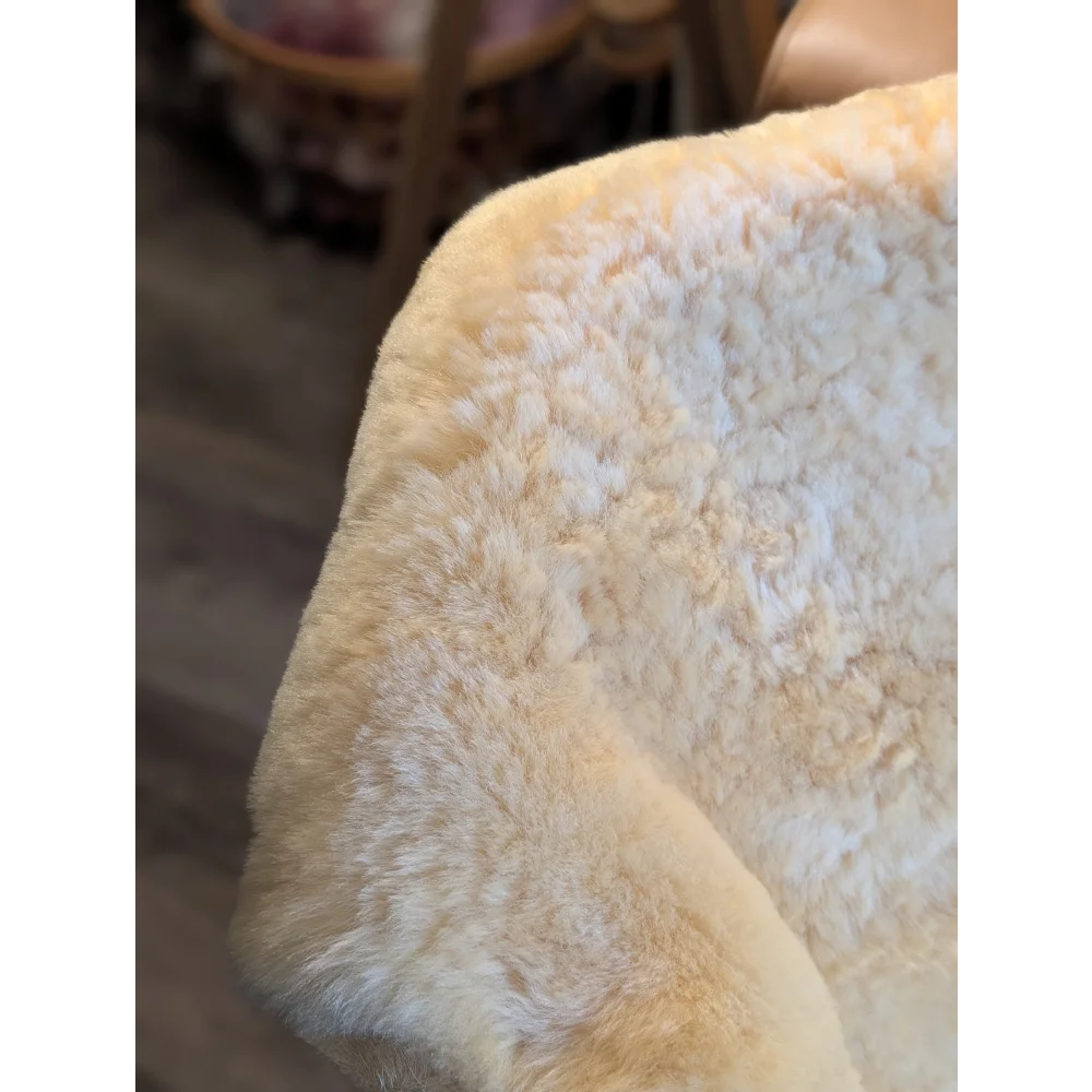 Cream-colored extra large medical sheepskin chair cushion with soft fluffy texture by angus oliver