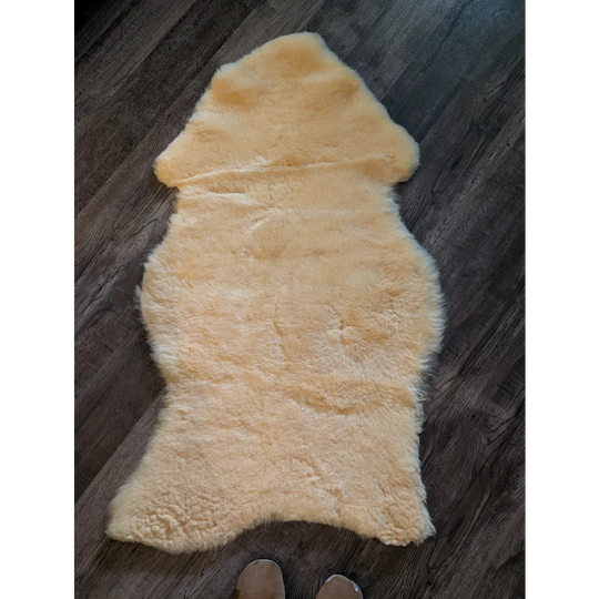 A soft creamy beige extra large medical sheepskin rug with plush natural fur texture by angus oliver