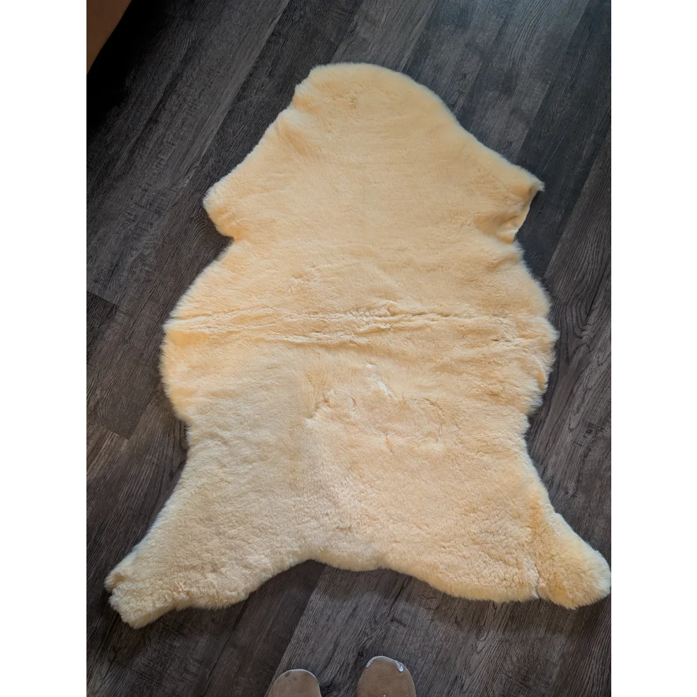 Cream-colored medical sheepskin rug with soft fluffy texture and natural edges by angus oliver large 46 x 29 inches