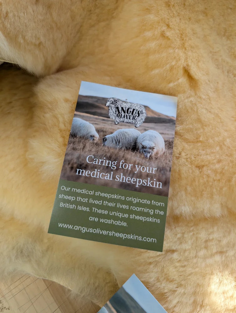 A rectangular card with sheep photo and angus oliver text on a soft tan medical sheepskin for medical sheepskins