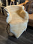 Cream-colored medium medical sheepskin throw draped over modern armchair with slender wooden legs by angus oliver