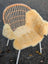 Woven rattan chair with white metal legs draped in soft beige angus oliver medical sheepskin washable cover