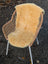 A cozy light tan washable medical sheepskin throw draped over a wicker chair with white metal legs by angus oliver british sheepskins