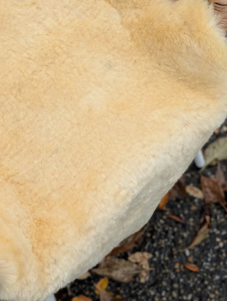 Cream-colored plush medical sheepskin with soft fluffy texture naturally spotted washable 52 x 31 inches