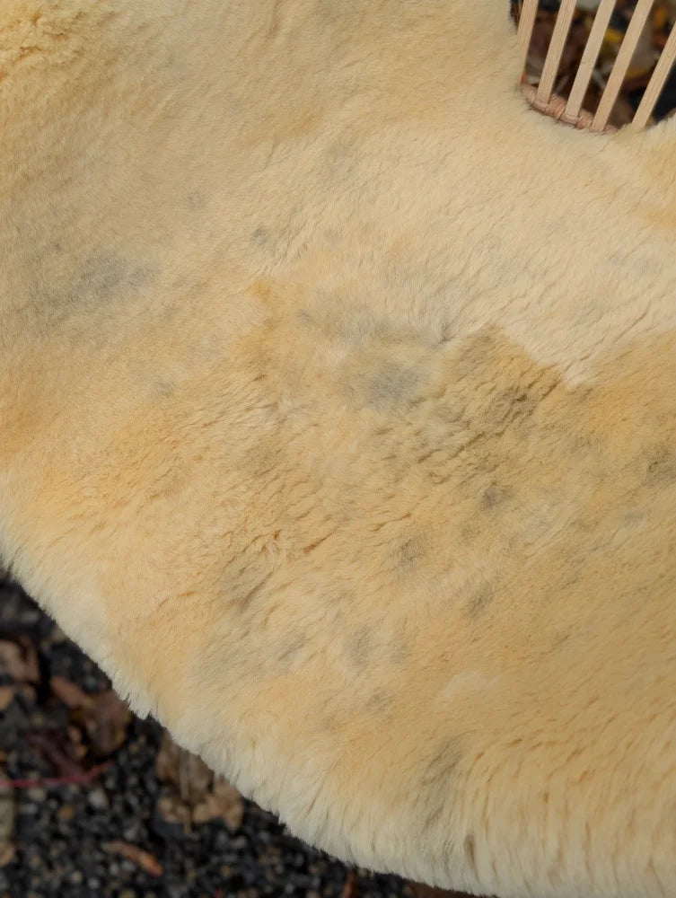 Cream-colored plush medical sheepskin rug naturally spotted with soft textured surface washable 43.5 x 28 inches