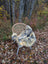 A cozy naturally spotted medical sheepskin in gray and yellowish brown draped over a wicker chair back