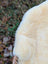 Cream-colored naturally spotted medical sheepskin with soft fluffy texture and natural fiber weave for medical use