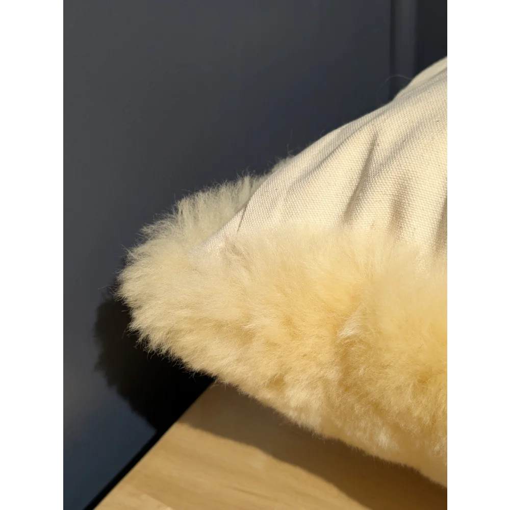 Cream-colored medical sheepskin cushion with plush fluffy sheepskin trim for cozy cushion cover comfort