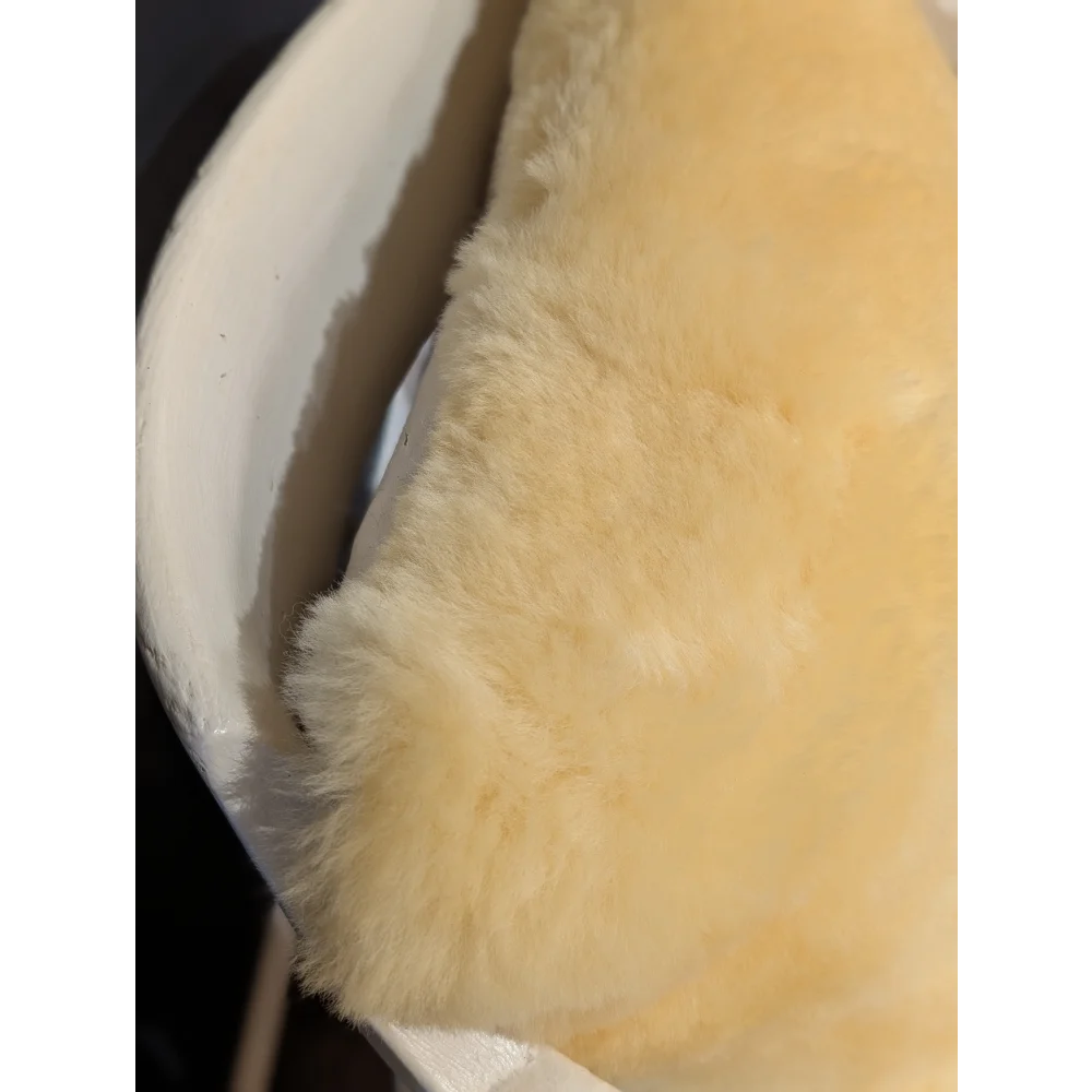Soft creamy yellow sheepskin lining with plush texture on medical sheepskin cushion cover for comfort and support