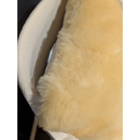 Soft creamy yellow sheepskin lining with plush texture on medical sheepskin cushion cover for comfort and support