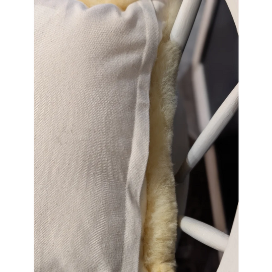 Off-white medical sheepskin cushion cover with soft fluffy yellow interior lining for comfort and support