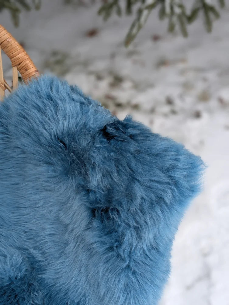 A plush vibrant blue merino sheepskin throw blanket with soft fluffy texture perfect for mid october cozy nights