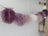 Medium pink sheepskin pom pom garland with lavender white fur and rustic wood handle