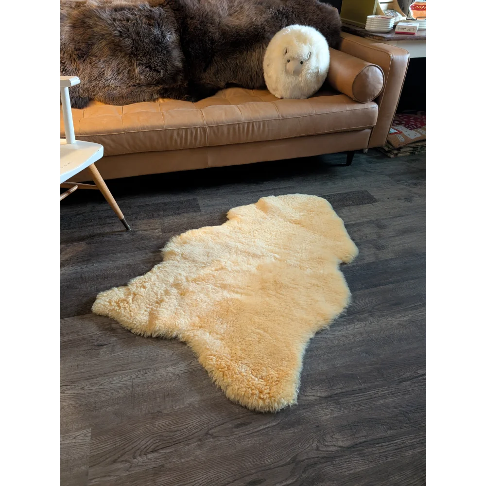 Cream-colored medium medical sheepskin rug with soft fluffy texture and natural edges by angus oliver