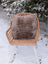 Medium taupe merino sheepskin cushion cover with soft faux fur front and cotton backs on wicker chair