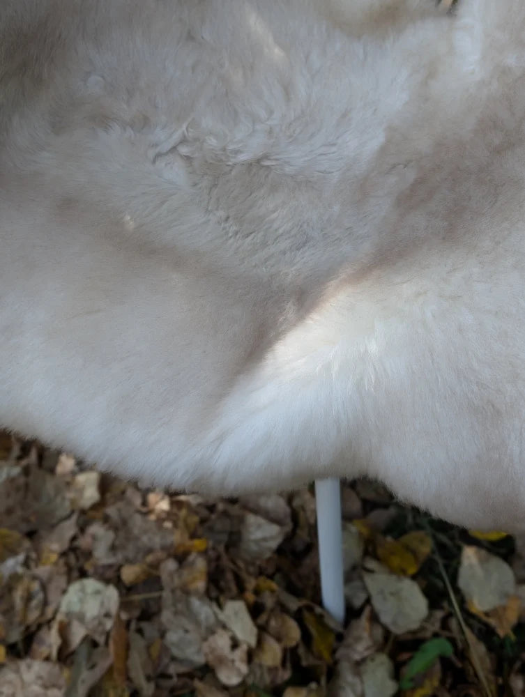 A plush off-white faux fur coat made from british isles sheepskin with a soft textured surface perfect for cozy wear