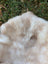 A soft cream-colored plush british isles sheepskin faux fur blanket with subtle beige mottling mel2 45 x 31 inches
