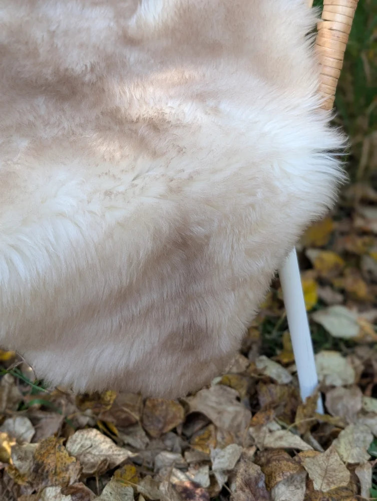 A soft cream-colored faux fur throw with plush texture in mel3 46 x 29 british isles sheepskin style