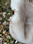 A soft cream-colored plush faux fur hood from mel3 british isles sheepskin measuring 46 x 29 inches