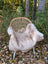 Beige british isles sheepskin faux fur throw draped over wicker chair with white metal legs for cozy style