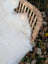A fluffy white cat resting in a woven basket on a british isles 45 x 30 sheepskin rug