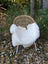 White faux fur throw draped over a wicker chair with metal legs in a british isles sheepskin style