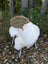 White fluffy british isles sheepskin throw draped over a wicker chair with metal legs for cozy decor