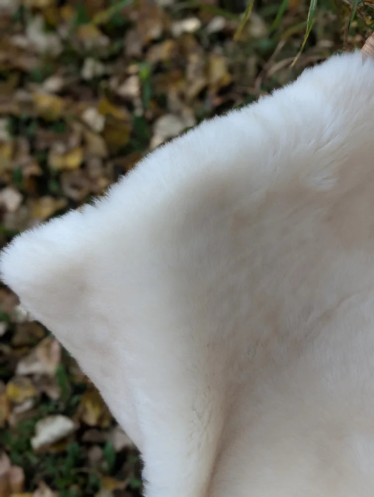 A plush white faux fur throw blanket with soft fluffy texture from the british isles sheepskin collection