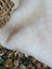 A soft off-white british isles sheepskin rug with plush texture and irregular edges perfect for cozy decor