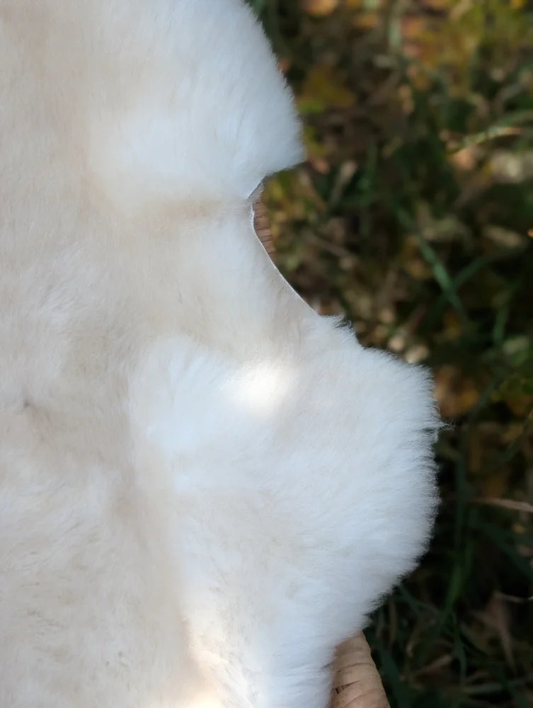 A plush off-white faux fur coat with soft fluffy texture made from british isles sheepskin for cozy style